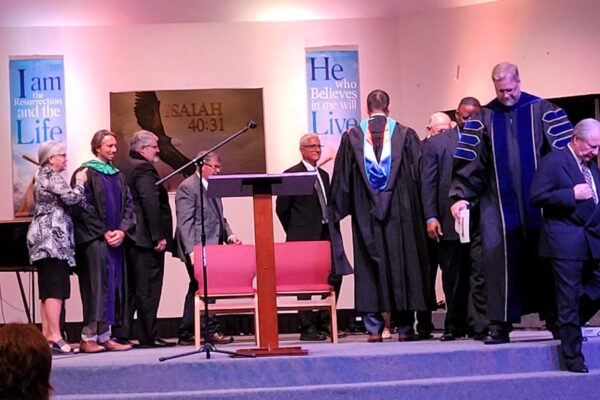 The board of trustees congratulating Dr. Best